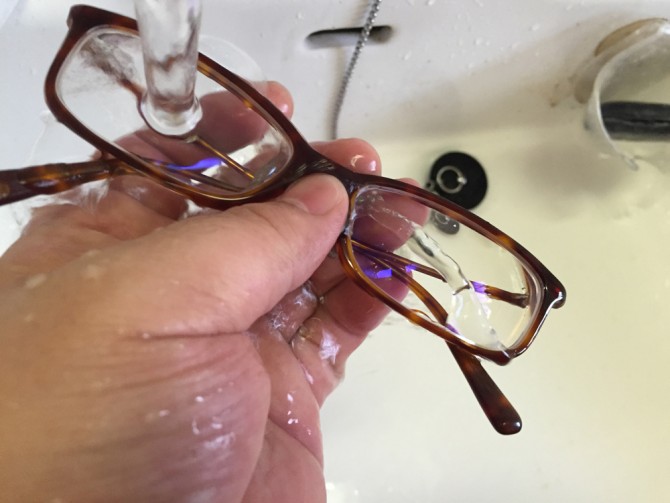 メガネのシャンプーの泡を水で流す
